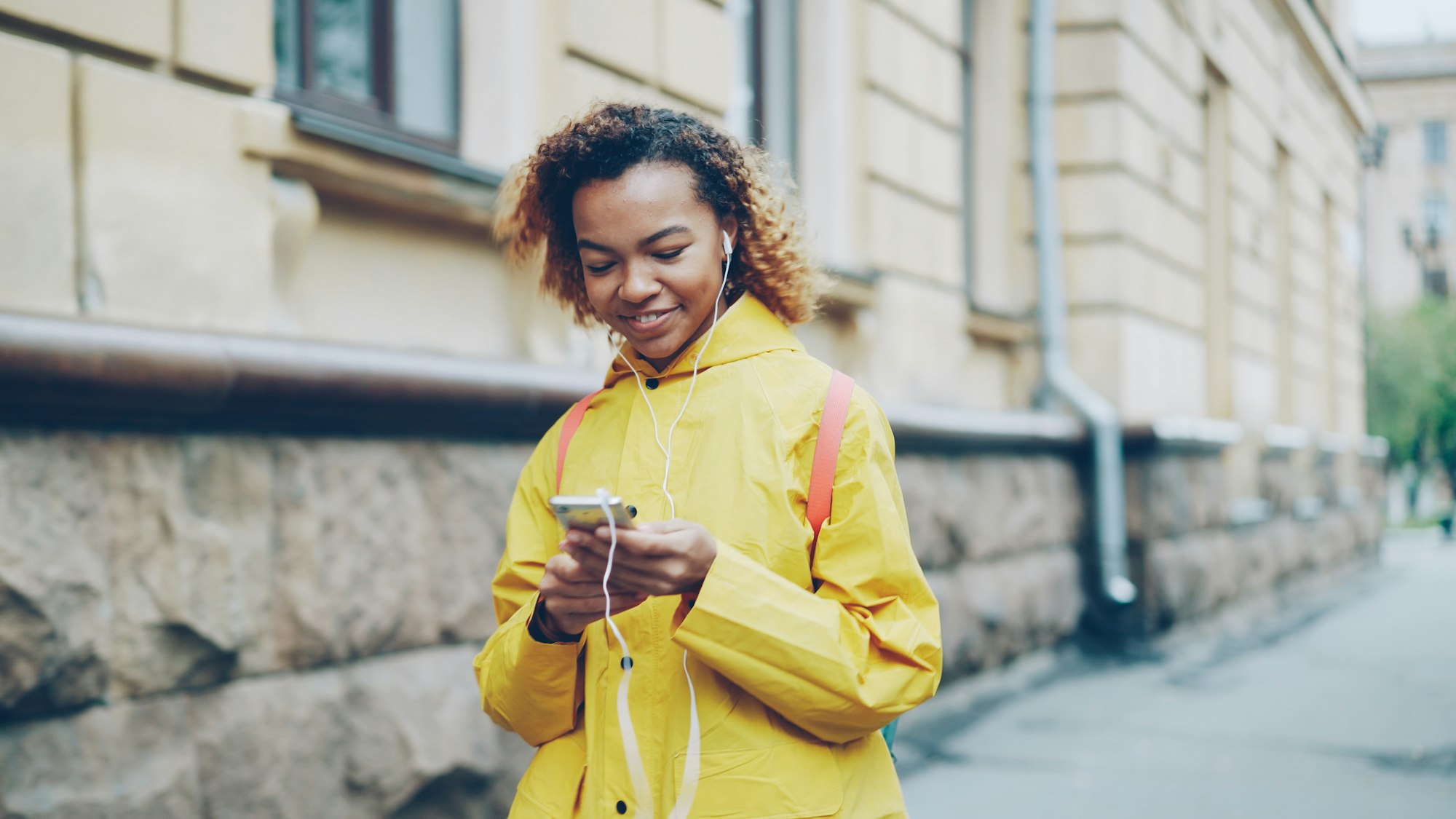 Une femme sourit en lisant un message de paiement sur son téléphone
